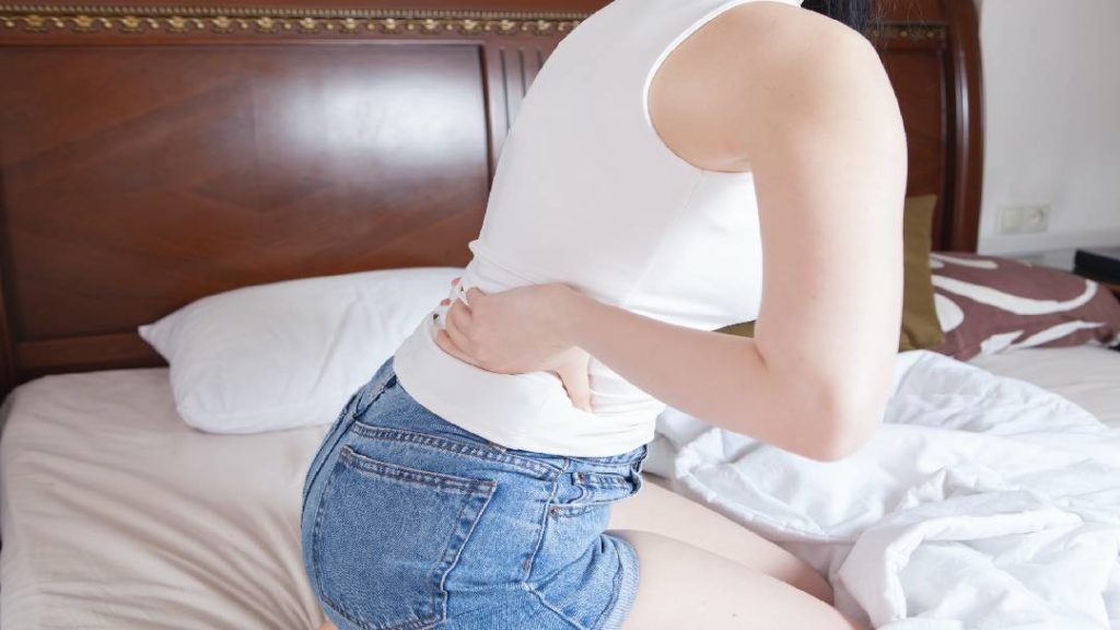 women grasping back from pain
